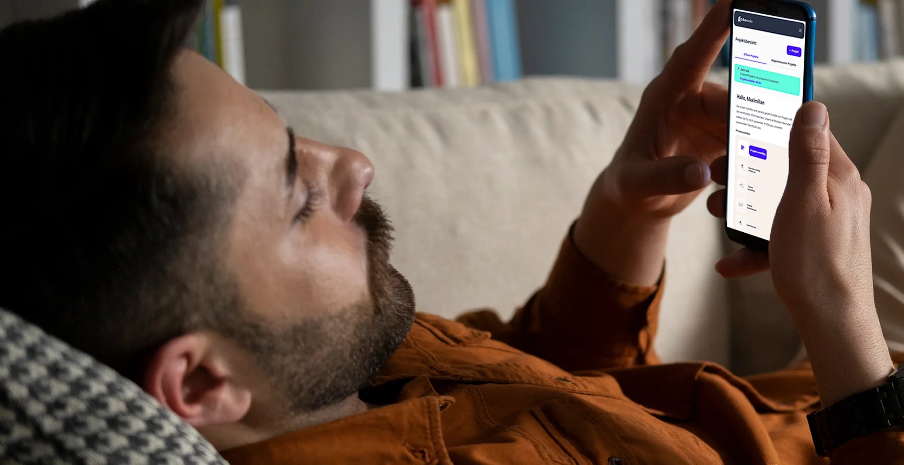 Mann liegt auf der Couch und nutzt die KI-gestützte Projekterstellung der Freelancer-App tribeworks.