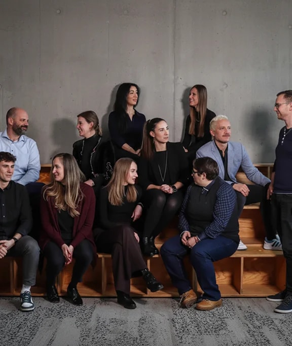 Teamfoto mehrerer Personen im beruflichen Umfeld.