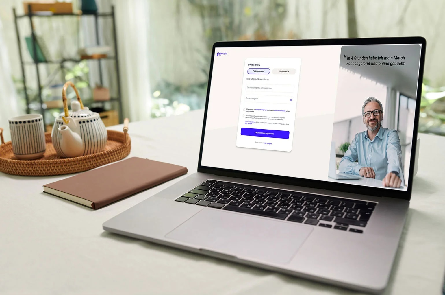 Laptop auf einem Schreibtisch zeigt die Benutzeroberfläche einer Freelancer Plattform mit Login‑Maske und Profilansicht, umgeben von Notizbuch und Wohnaccessoires in ruhiger Arbeitsumgebung.