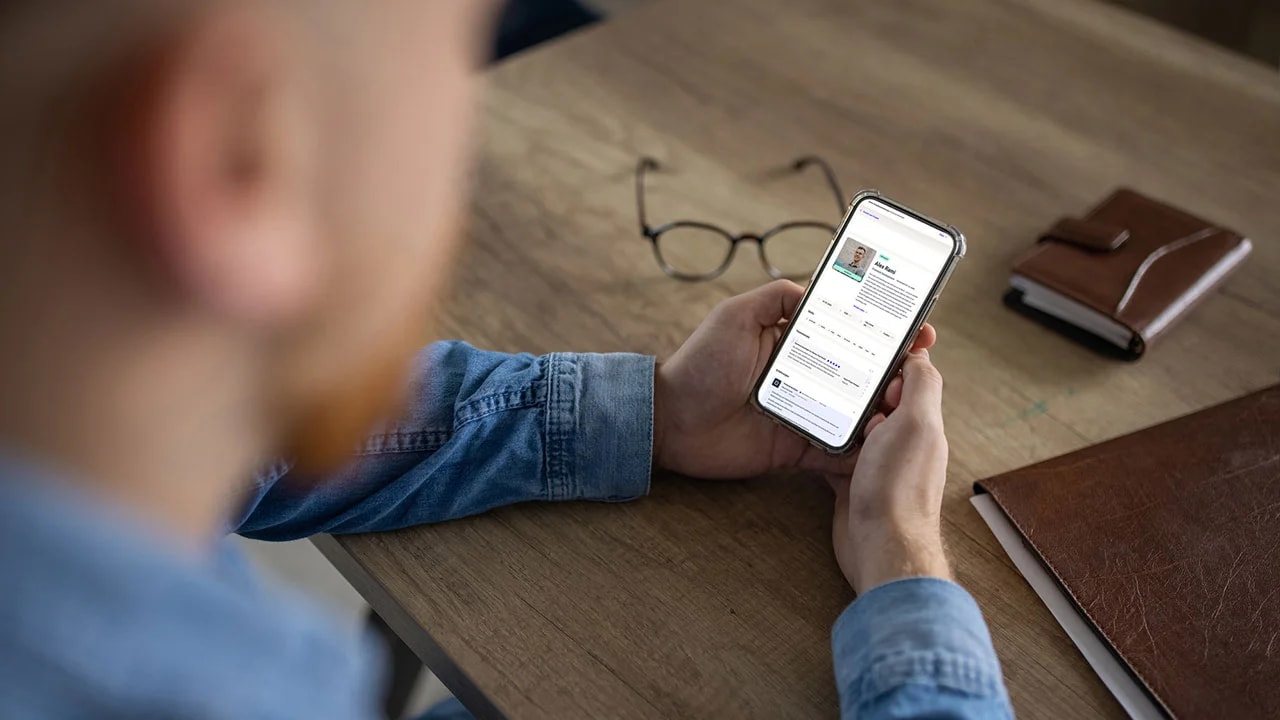 Person betrachtet ein Freelancer‑Profil auf dem Smartphone. 