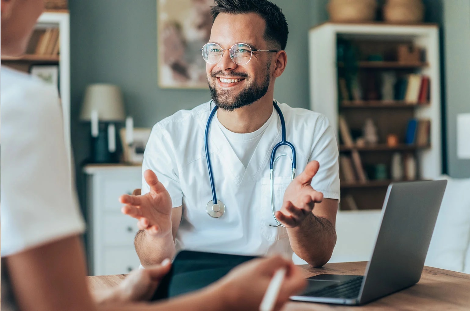 Arzt mit Stethoskop spricht mit einer selbständigen Person über Versicherungen.