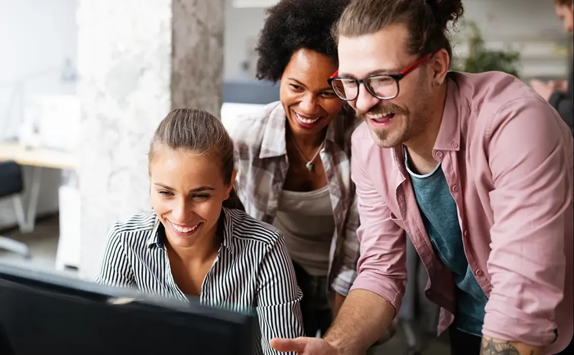 Gemeinsame Abstimmung vor einem Laptop in einem Arbeitsumfeld als visuelle Darstellung von Projektarbeit über eine IT Freelancer Website.